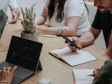 Persone in riunione di team nello spazio di coworking dell'hotel AMA Stay a San Vigilio in Alto Adige.