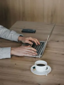 Scrivania con Notebook e caffé nel spazio coworking di AMA Stay